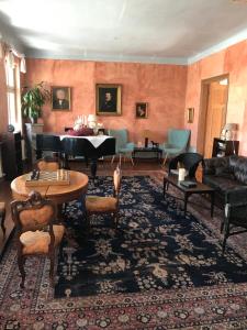 a living room with a grand piano and furniture at Hotel Alte Försterei in Kloster Zinna