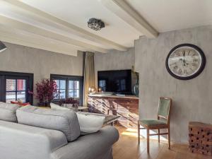 Una sala de estar con un sofá y un reloj en la pared. en LaneStay DamSquare, en Ámsterdam