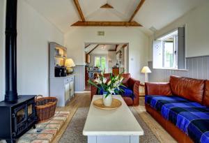 a living room with a couch and a stove at East Green Farm Cottages - The Old Stables in Saxmundham