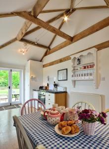 a kitchen with a table with a blue and white checkered table cloth at East Green Farm Cottages - The Old Stables in Saxmundham