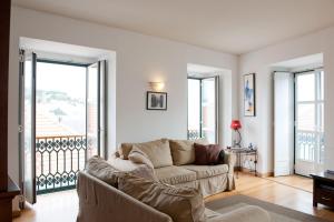a living room filled with furniture and a window at Lisbon Charming Apartments - Chiado in Lisbon