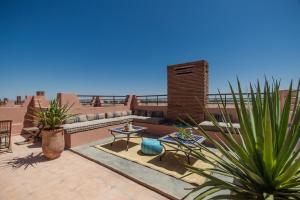 een patio met een bank, een tafel en planten bij Villa Nelya in Marrakesh