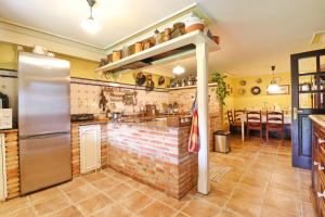 a kitchen with a refrigerator and a brick wall at Casa Os Curras in Culleredo