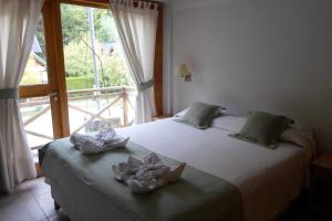 1 dormitorio con cama y ventana grande en Apart Hotel Robles del Sur en San Martín de los Andes