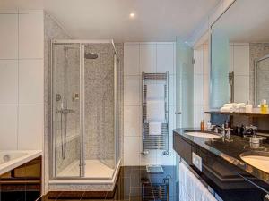 a bathroom with a shower and two sinks at Fairmont Le Montreux Palace in Montreux