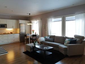 a living room with a couch and a table at ANNA - Modern flat with Sauna - 24h Check in in Närpiö