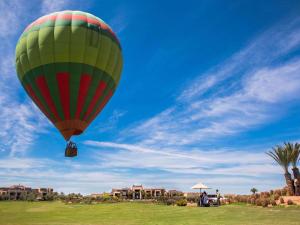einem Heißluftballon, der über ein Feld fliegt in der Unterkunft Fairmont Royal Palm Marrakech in Marrakesch