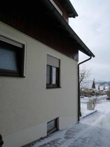 a house with snow on the side of it at Ferienwohnung Reitinger in Rötz