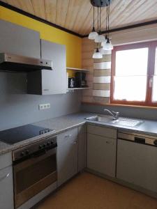 a kitchen with white cabinets and a sink and a window at Ferienwohnung Reitinger in Rötz