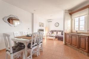 een keuken en eetkamer met een tafel en stoelen bij Apartamento San Juan 18 in Nerja