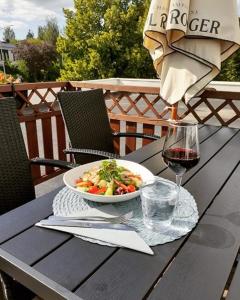 una mesa con un tazón de comida y una copa de vino en Teatterihotelli Riihimäki en Riihimäki