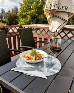 a table with a bowl of food and a glass of wine at Teatterihotelli Riihimäki in Riihimäki