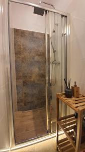 a shower stall in a bathroom with a wooden table at Apartament Za Murami Gliwice in Gliwice