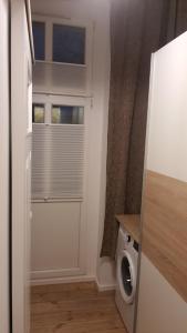 a laundry room with a washing machine and a window at Apartament Za Murami Gliwice in Gliwice