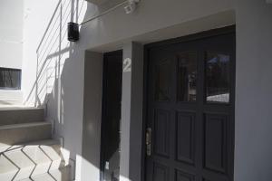 una puerta negra con un número en el costado de un edificio en Departamentos Victoria, en Paraná