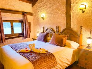 a bedroom with a bed with two swans on it at Posada Real de Carreteros in Casarejos