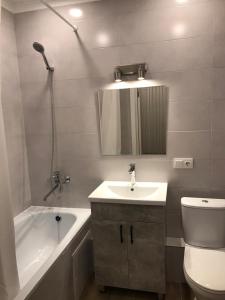 La salle de bains est pourvue d'un lavabo, d'une baignoire et de toilettes. dans l'établissement Стильная однокомнатная квартира в г.Алматы, à Almaty