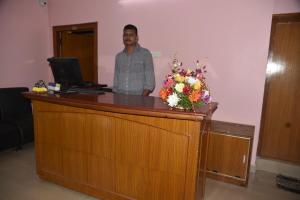 um homem parado na recepção com um computador em Royal Stay em Visakhapatnam