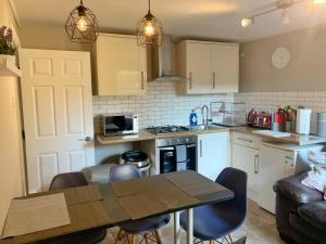 a kitchen with a wooden table and chairs in a room at Central City Garden Apartment in Cardiff