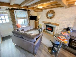 een woonkamer met een bank en een open haard bij Pilchard Cottage in Brixham