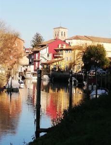 einen Fluss mit Booten in einer Stadt mit Gebäuden in der Unterkunft B&B Velocipede in Cervignano del Friuli
