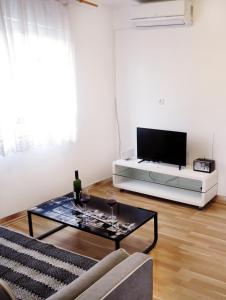 sala de estar con TV y mesa de centro en Apartment Jadro, en Supetar