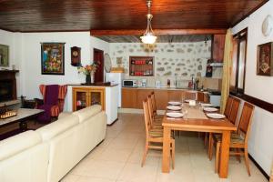 a dining room and kitchen with a table and a couch at Self Catering Chalet Kulina in Bansko