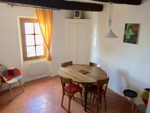 a dining room with a wooden table and chairs at LA MAISON D’ALICE in Sault-de-Vaucluse