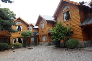 Casa de madera grande con entrada de grava en Apart Hotel Robles del Sur en San Martín de los Andes