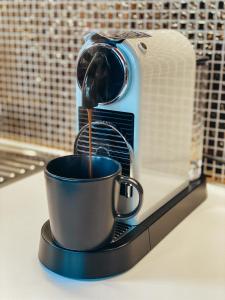 a coffee maker pouring coffee into a cup on a counter at Villa Gaida in Saulkrasti