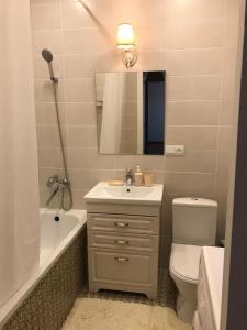 a bathroom with a sink and a toilet and a mirror at Стильная и уютная однокомнатная квартира в г.Алматы in Almaty