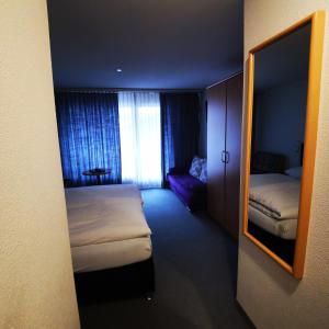 ein Hotelzimmer mit 2 Betten und einem Spiegel in der Unterkunft Hotel Crystal in Adelboden