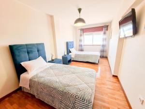 1 dormitorio con 1 cama y TV en House in beach- Oporto, en Arcozelo