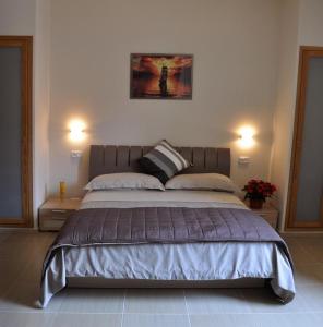 アグローポリにあるVecchio Saracino - Carola 1801の大型ベッド1台(2つの照明付)が備わるベッドルーム1室