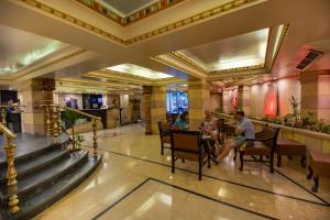 un vestíbulo de un hotel con gente sentada en las mesas en Zayed Hotel, en El Cairo