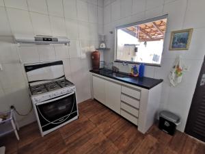 a small kitchen with a stove and a sink at Suíte Capitólio in Capitólio