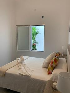 a bedroom with a large bed with a palm tree outside the window at Alojamientos Agaete Pueblo N11 in Agaete