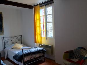 um quarto com uma cama e uma janela em LA MAISON D’ALICE em Sault-de-Vaucluse