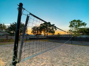 a volleyball net with the sun setting behind it at Sun Outdoors Texas Hill Country in New Braunfels