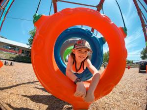 a young girl is playing on a playground at Sun Outdoors Texas Hill Country in New Braunfels