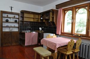 cocina con mesa, mesa y sillas en APARTAMENT STELLA en Kościelisko