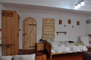 1 dormitorio con puerta de madera, 1 cama y 1 habitación en APARTAMENT STELLA en Kościelisko