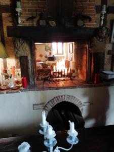 a fireplace in a living room with a fire place at Maison d'Hotes Le Chai d'Armagnac in Monguillem