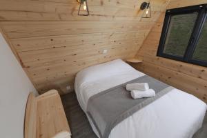 - une chambre avec un lit dans une cabane en bois dans l'établissement Ô TIPI LODGE, à Saint-Christo-en-Jarez