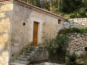 ein Steingebäude mit einer Treppe, die zu einer Tür führt in der Unterkunft La Maison des Sources in Angoulême