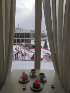 a table with plates and cups and a window at 7 Sky on Shchorsa Street in Kyiv