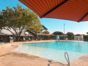 uma grande piscina com telhado vermelho em Sun Retreats Texas Hill Country em New Braunfels