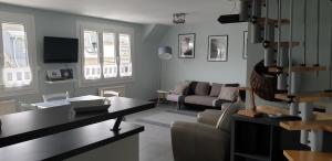 a living room with a couch and a table at Port de La Houle - Beau 3 pièces classé 3 étoiles avec garage privé in Cancale