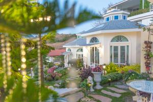 a house with a garden in front of it at Prim's Cottage in Khao Kho