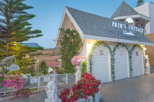 un edificio blanco con flores delante en Prim's Cottage en Khao Kho